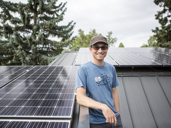 Homeowner on roof with solar panels